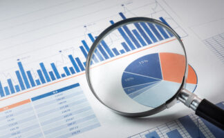 Magnifying glass and business growth graph / financial graph on paper./ For business concept.